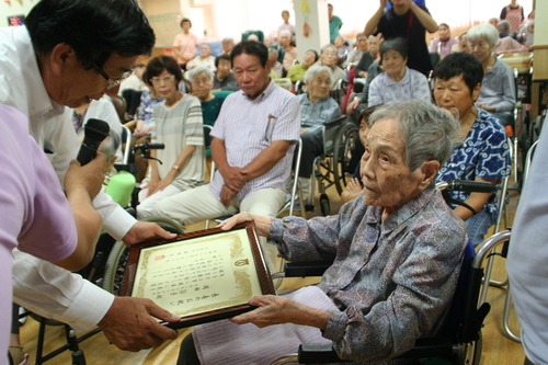 画像：市長から祝い状を受け取る市内最高齢者の岡田 静子さん（満103歳）