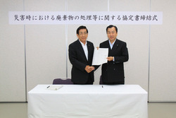 協定書を取り交わす服部市長と永井会長の画像