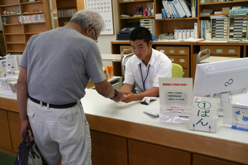 画像：図書館で貸し出し業務を体験する学生