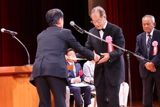 市制施行20周年記念表彰において、服部勇次氏が安藤市長より表彰状を受け取る様子